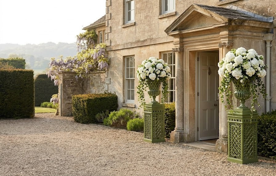 Pair of lattice urns on pedestals at a manor doorway
